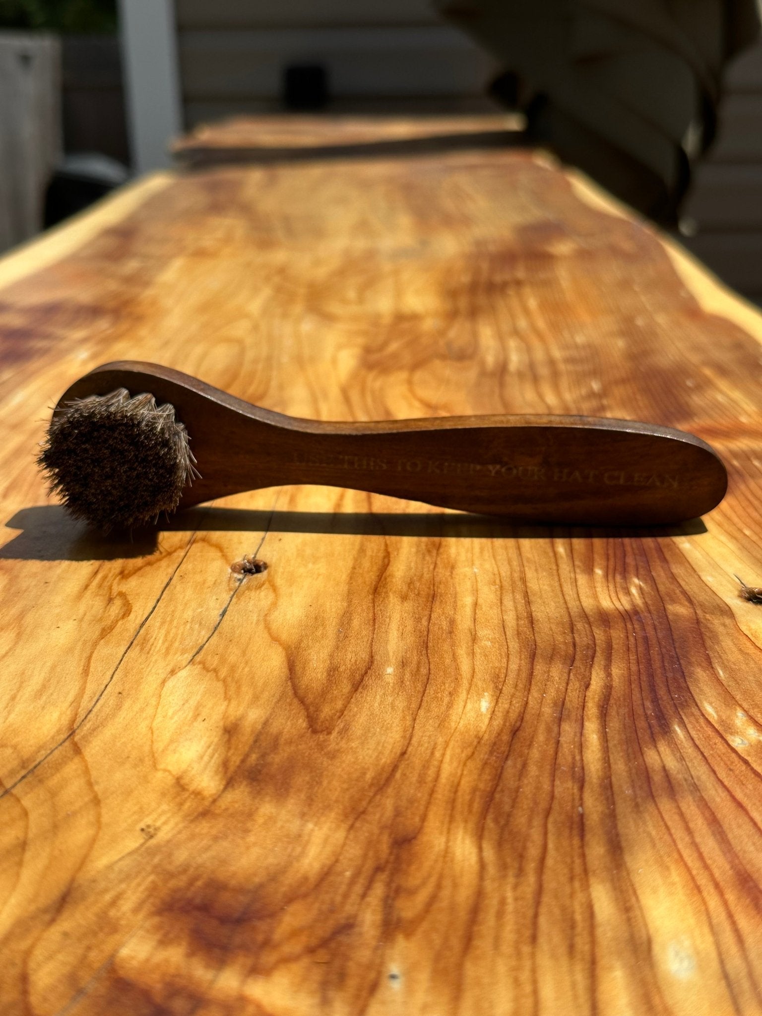 Wooden brush with bristle head on a wooden surface